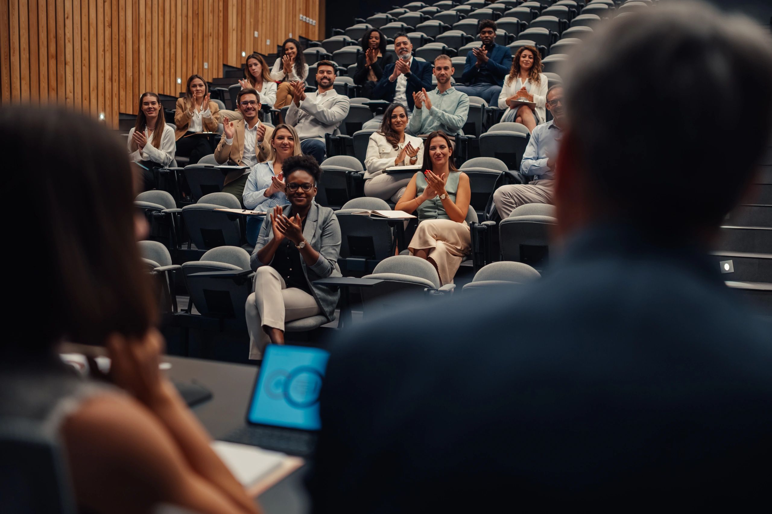 Professionals attending a training conference and applauding a presentation